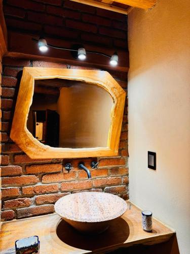 a bathroom with a stone sink and a mirror at Cabañas Villa Escondida in Urique