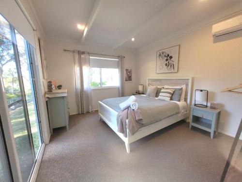 a bedroom with a bed and a window at Waterfront Retreat by Book Jervis Bay Getaway Kayaks, Bikes, Fast Wi-Fi and more in Sanctuary Point
