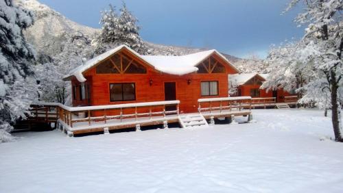 a log cabin in the snow with snow at Cabañas Mawidantu Lemu in Las Trancas