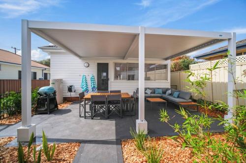 a covered patio with a couch and a table at Summer Breeze Forster in Forster
