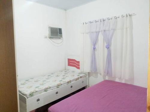 a small bedroom with a bed and a window at Casa do Barney Enseada Guaruja in Ilha de Santo Amaro