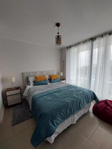 a bedroom with a large bed and a large window at Sunrise in La Serena