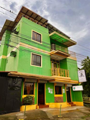 a green building with a balcony on top of it at Princesa el gallo inn in Puerto Princesa City