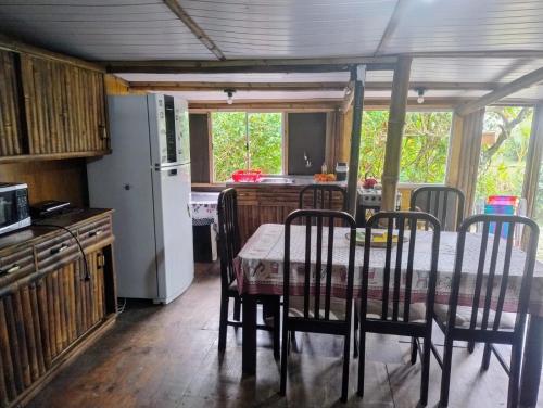 a kitchen with a table with chairs and a refrigerator at Loft frente ao mar para 6 pessoas na Ilha do mel in Ilha do Mel