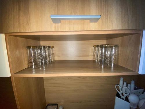 a wooden shelf with two wine glasses on it at CASA ROMÁN Habitación en Providencia con áreas compartidas in Santiago
