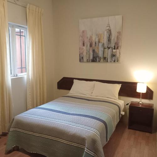 a bedroom with a bed and a window at The Place Miraflores in Lima