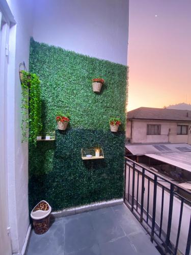 a green wall with potted plants on a balcony at CASA ROMÁN Habitación en Providencia con áreas compartidas in Santiago