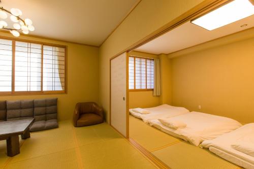 a room with two beds and a chair and a mirror at Himalaya Cloud Hotel in Tokyo