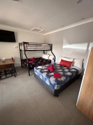 a bedroom with two bunk beds and a desk at Beagle Hotel in Katherine