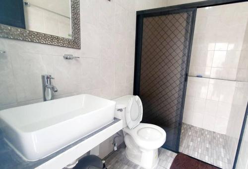 a bathroom with a white sink and a toilet at Casa Girasoles Valladolid Yucatán in Santa Bárbara