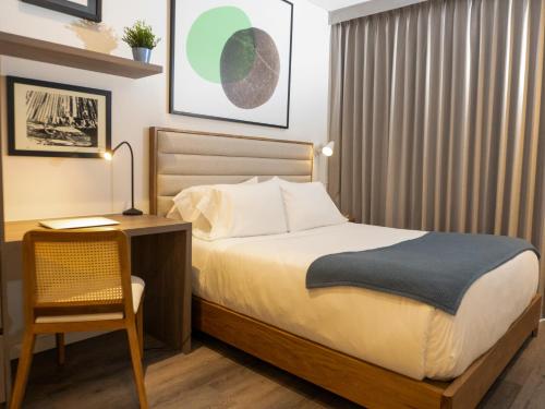 a bedroom with a bed and a desk and a chair at Art Homes 85 in Bogotá
