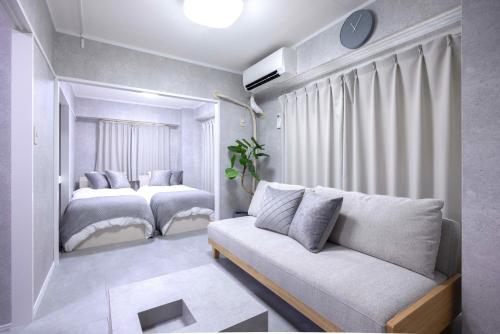 a living room with two beds and a couch at 1 line to Asakusa! Modern Room, 5 mins walk from Togoshi-ginza Sta in Tokyo