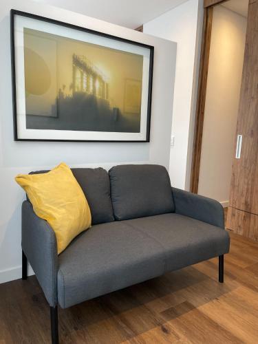 a couch with a yellow pillow on a wall at Art Homes 85 in Bogotá