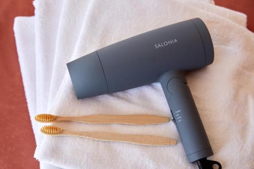 a hair dryer and two brushes on a towel at 一棟貸し別荘 mitt house inn in Numata