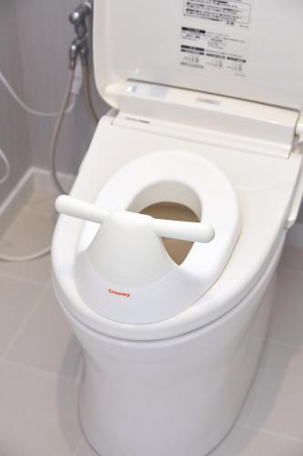 a white toilet with the seat up in a bathroom at 一棟貸し別荘 mitt house inn in Numata