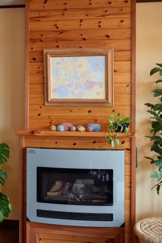 a fireplace in a living room with a painting above it at 一棟貸し別荘 mitt house inn in Numata
