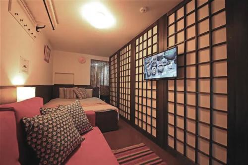 a room with a bed and a tv in it at Kujo Keshi no Hana in Osaka