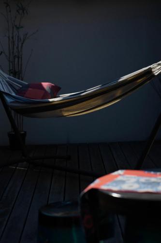 a hammock in a room with a chair and a table at Kujo Keshi no Hana in Osaka