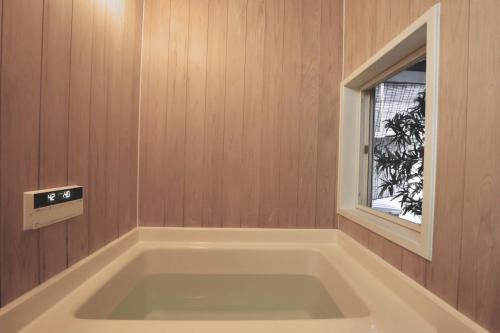 a bath tub in a room with a window at Kujo Keshi no Hana in Osaka