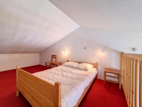 une chambre avec un grand lit dans un grenier dans l'établissement Appartement cosy · Proche pistes · Balcon · Parking privé - FR-1-344-1199, aux Menuires