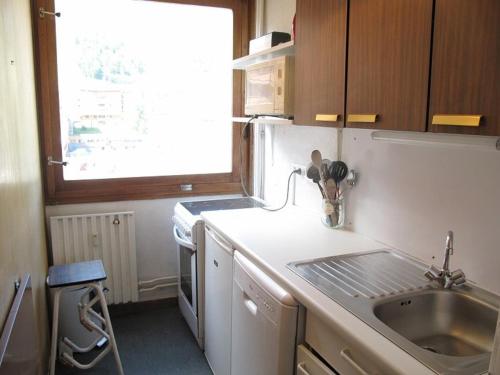 une petite cuisine avec un évier et une fenêtre dans l'établissement Spacieux 3 pièces Plagne Centre, balcon, casier à ski, animaux admis - FR-1-351-208, à La Plagne Tarentaise