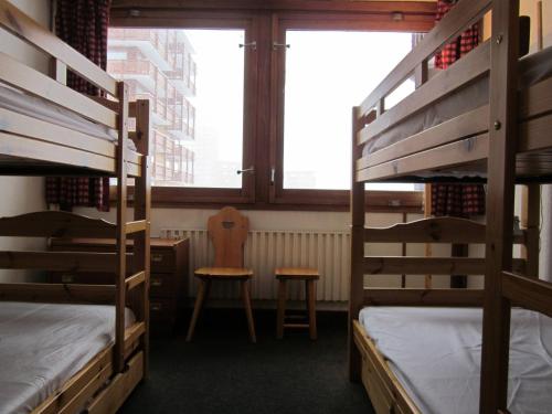Ce dortoir comprend 2 lits superposés et une chaise. dans l'établissement Spacieux 3 pièces Plagne Centre, balcon, casier à ski, animaux admis - FR-1-351-208, à La Plagne Tarentaise