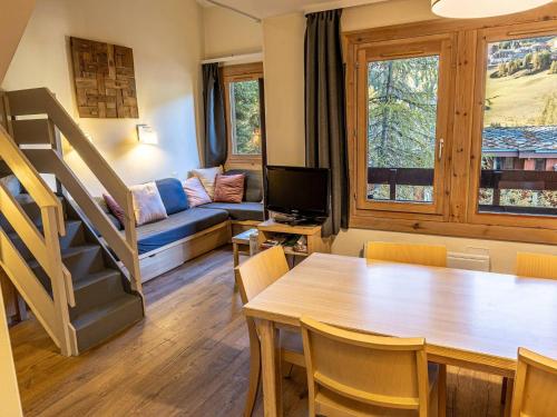 - un salon avec une table à manger et un canapé dans l'établissement Duplex spacieux 2 chambres avec piscine commune - La Plagne - FR-1-351-211, à La Plagne Tarentaise