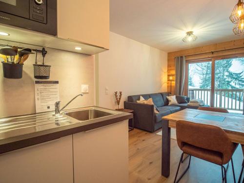 une cuisine et un salon avec un canapé et une table dans l'établissement Valmorel: Appt 6 pers, 2 ch, parking, wifi, skis aux pieds - FR-1-356-511, à Valmorel