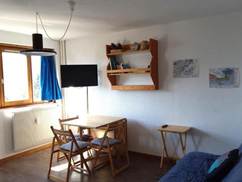 Cette chambre comprend un bureau, une table et des chaises. dans l'établissement Appartement 4 pers, 1 chambre, proche pistes, ascenseur, balcon - FR-1-411-949, à Bourg-Saint-Maurice