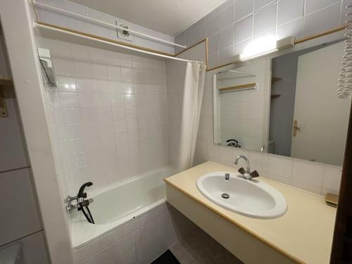 une salle de bain avec un lavabo, une baignoire et un miroir dans l'établissement Studio agréable en station - Animaux admis - FR-1-787-76, à Laveissière
