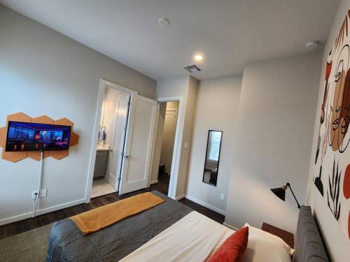 a bedroom with a bed and a tv on the wall at Galleria Premium 3 Story Home Sleeps 8 in Houston