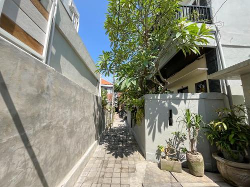 an alley with trees and plants on the side of a building at Adi surya guest house in Seminyak