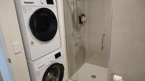 a washer and dryer in a bathroom with a shower at La Quinta by Wyndham Parnell Auckland in Auckland