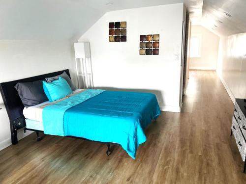 a bedroom with a blue bed and a wooden floor at Cozy Studio Loft Near Downtown in Columbus