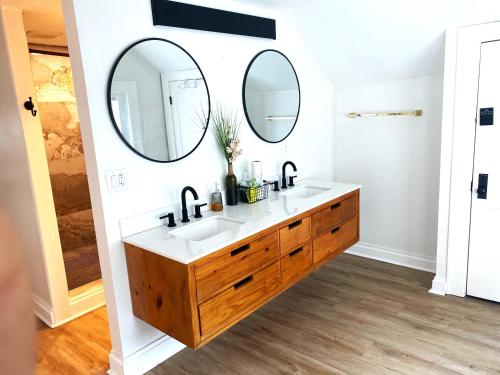 a bathroom with two sinks and two mirrors at Cozy Studio Loft Near Downtown in Columbus