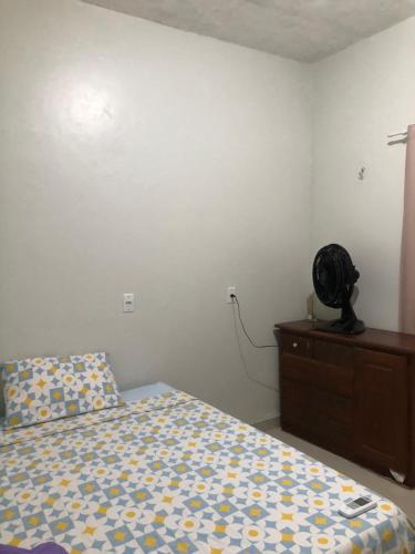 a bedroom with a bed and a dresser with a fan at Festival de Parintins -2025 in Parintins