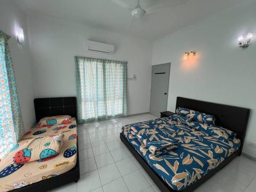 a bedroom with two twin beds in a room at Orchard Lake House - Entire bungalow, 4 rooms, 9 beds, 13 persons in Behrang Hulu