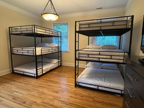three bunk beds in a room with wood floors at Beautiful River front home with private pool in Phillipsburg