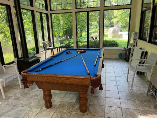 a pool table in a room with windows at Beautiful River front home with private pool in Phillipsburg