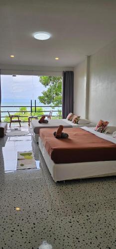 three beds in a room with a large window at Viking Holiday Resort in Ko Samed