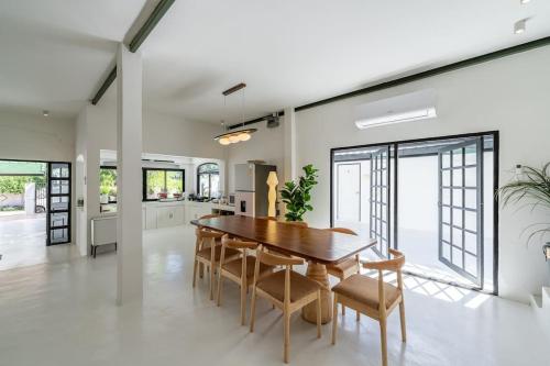 a kitchen and dining room with a wooden table and chairs at Stunning Pool Villa - In Old Town Chiang Mai Daily Housekeeping in Chiang Mai
