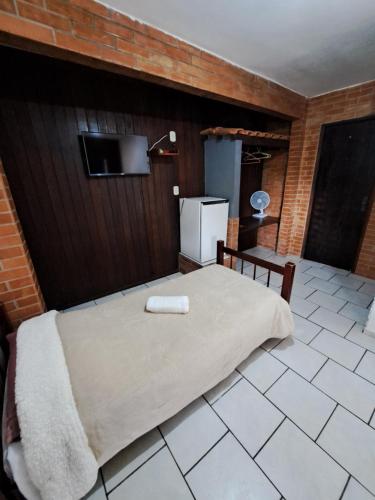 a bedroom with a bed with a towel on it at Pousada Luar de Penedo in Penedo