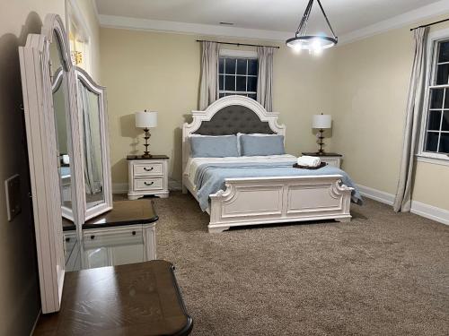 a bedroom with a bed and two tables and a mirror at Beautiful River front home with private pool in Phillipsburg
