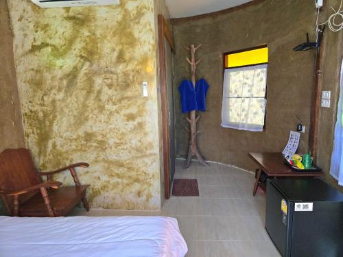 a bedroom with a bed and a desk and a window at โอบสุขโฮมสเตย์ Oob-Suk in Ban Mae Cho