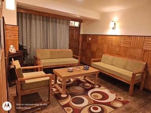 a living room with a couch and a table at Mudita Stays in Darjeeling