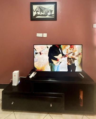 a flat screen tv with a video game on it at Home away from home in Namugongo