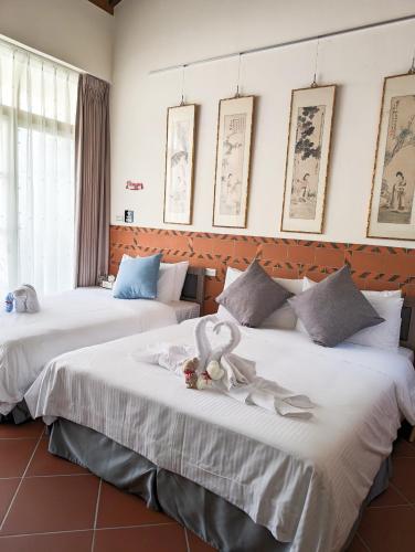 two beds in a room with towels on them at Lanshe Gate in Chung-lan