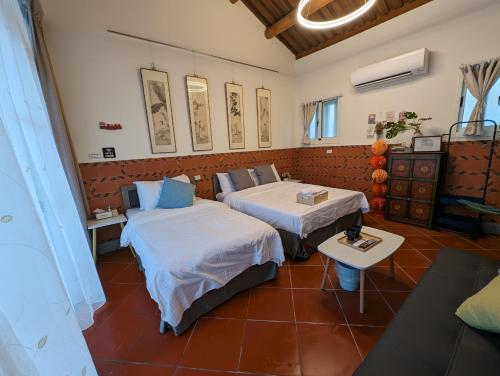 a hotel room with two beds and a table at Lanshe Gate in Chung-lan