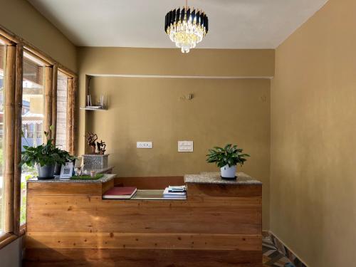 a room with a counter with potted plants and a chandelier at Hangkhim Homestay in Ravangla