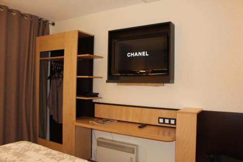 a hotel room with a tv and a bed at Euro Hôtel Airport Orly Rungis in Fresnes